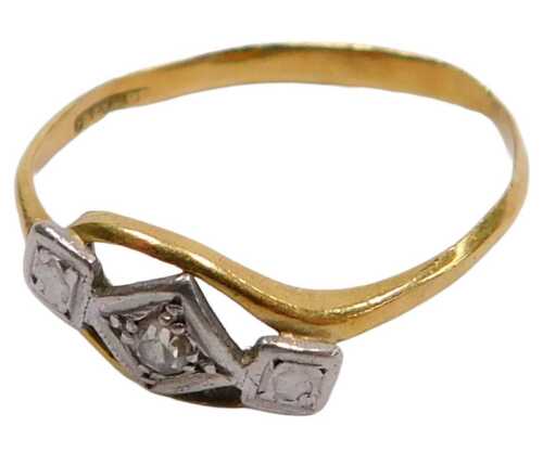 A mid century diamond three stone ring, in a cross over setting, in yellow and white metal...