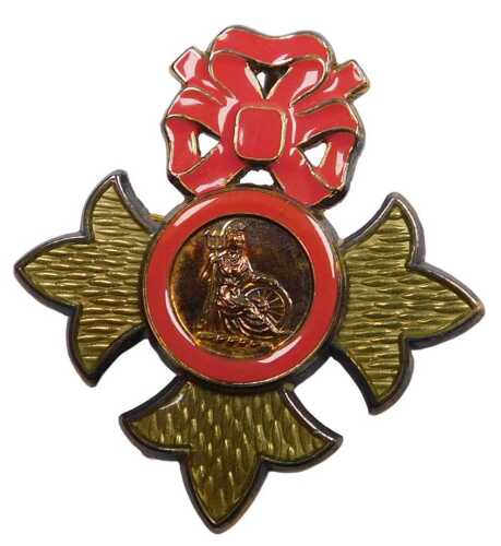 A miniature lady's gilt metal MBE badge, with pink enamel bow and band around Britannia, stamped...