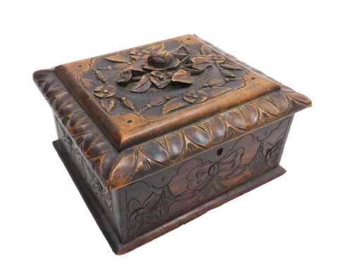 A late 19thC Black Forest wooden sewing box, the lid carved with flowers, 23cm wide, 20.5cm deep.