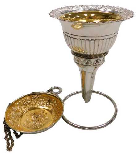 A Japanese silver and gold plated wine funnel, embossed with vines, together with a wine taster,...