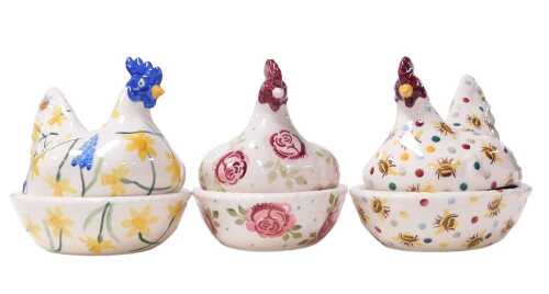 Three Emma Bridgewater pottery hen on nest egg baskets, decorated with daffodils, bees, or roses,...