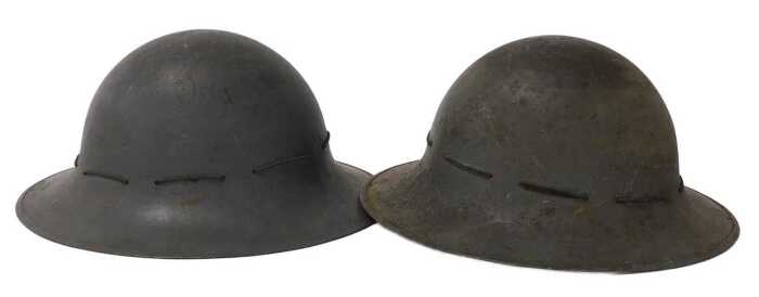 A pair of World War II Zuckerman Home Front military helmets, one dated 1941.
