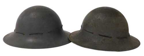 A pair of World War II Zuckerman Home Front military helmets, one dated 1941.