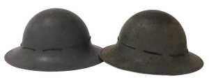 A pair of World War II Zuckerman Home Front military helmets, one dated 1941.