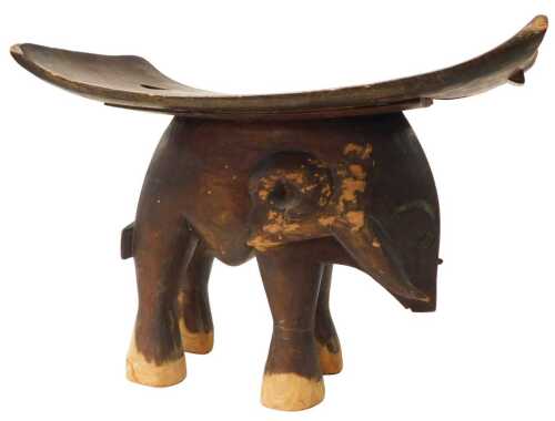 An African tribal stool, the base carved as a buffalo, 38cm high, 49cm wide.