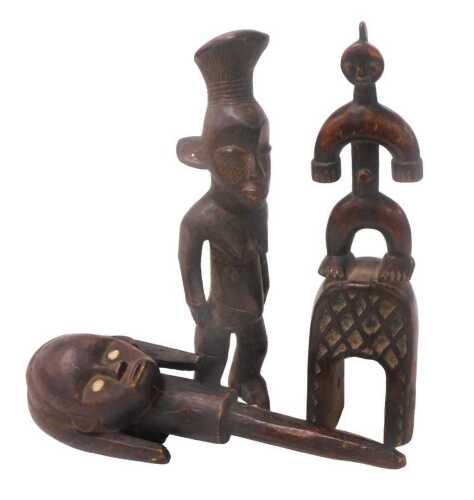 An African tribal female head, 41cm long, a West African carved wooden heddle pulley, and a...