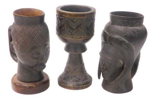 A Congolese Keba tribal cup, carved with jug, mask and horns, 19cm high, a similar cup, 20cm...