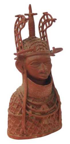 A Nigerian Benin red painted brass tribal figure of a warrior or cheiftan, wearing ornamental...