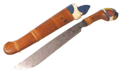 An Indonesian tribal knife, the handle carved and painted with a parrot's head, the scabbard...