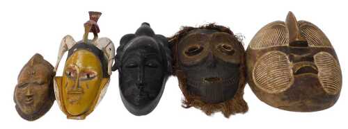 A Congolese Songye carved wooden tribal mask, 27cm high, a Baule mask, 30cm high, and three...
