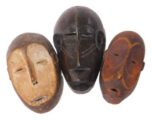 An African Congolese carved monkey shaped mask, 32cm high, and two further carved monkey masks,...