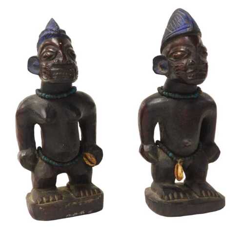 Two Nigerian Yoreba Ibeji tribal figures, each with blue painted headdresses, 25cm high.