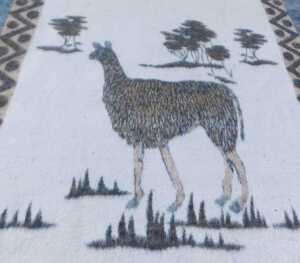 A late 20thC South African llama wool blanket, decorated with a llama and trees, within a... - 3