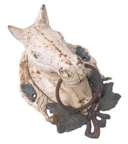 A painted cast iron plaque, depicting a horse's head with a ring through its mouth, 28cm high.