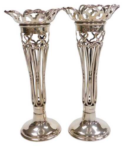 A pair of Edward VII silver stem vases, each with a fluted and pierced border and body, on a...