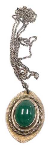 A silver pendant and chain, the oval cabochon polished green stone in rub over setting, on a...