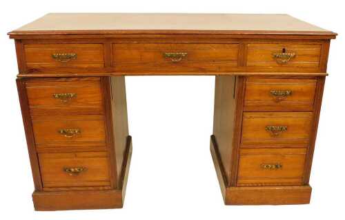 An early 20thC stained pine pedestal desk, the top with a moulded edge above an arrangement of...