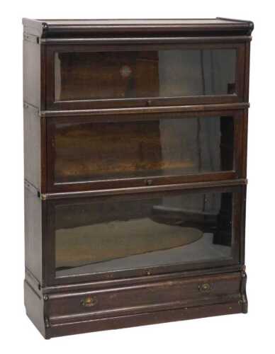 A Globe Wernicke oak three section bookcase, with three sliding glass doors, and a drawer to the...
