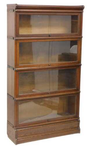 A Globe Wernicke style oak four section bookcase, with sliding glass doors, on a moulded base,...