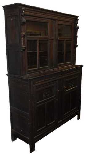 An 18thC and later oak cabinet, the top with a moulded edge above glass panelled doors enclosing...
