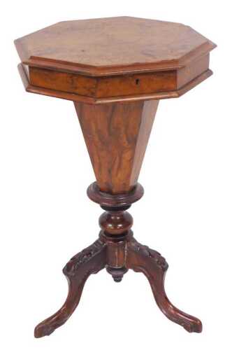 A Victorian walnut sewing table, the moulded octagonal hinged top enclosing an interior with an...