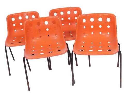 A set of four Robin Day Design moulded plastic stacking chairs, in burnt orange with pierced...
