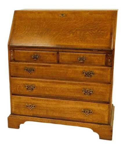 A 20thC oak bureau, in 19thC style, the fall enclosing an arrangement of recesses, drawers and a...