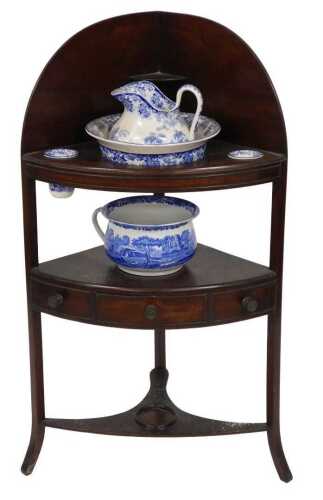 A George III mahogany corner washstand, with blue and white pottery jug and bowl set.