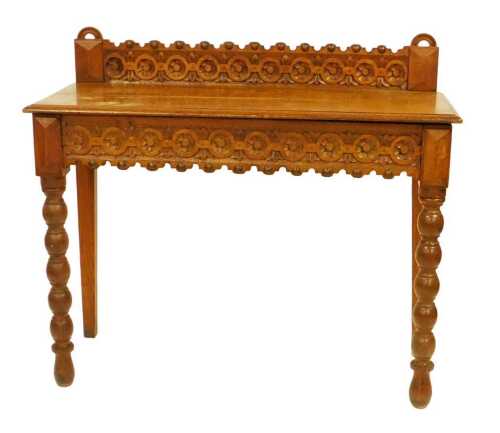 A late Victorian oak side table, with roundel carved frieze and bobbin turned legs, 108cm wide.