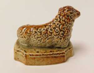A 19thC stoneware sheep, on a rectangular base, with re-entrant corners, 7cm long. VAT is... - 3