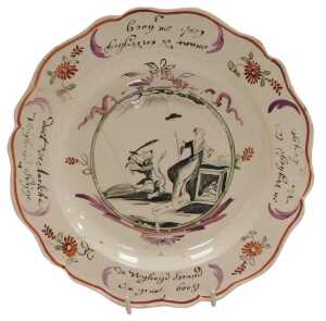 A late 18thC Leeds Creamware plate, Dutch decorated, the centre painted with a figure of Liberty...