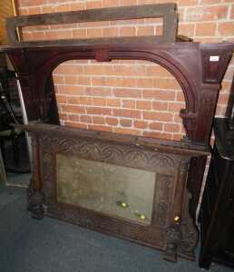 A late Victorian mahogany fireplace surround, the arched central section with carved and moulded...