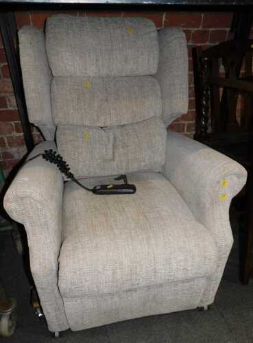 A beige upholstered rise and fall electric armchair.