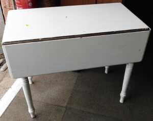 A white painted Victorian mahogany Pembroke table, raised on turned legs.
