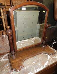 A Victorian mahogany swing frame toilet mirror, the arched mirror on part reeded cylindrical...