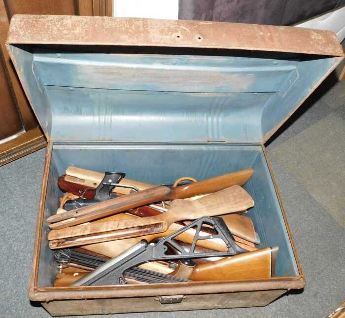 A tin trunk, containing wooden gun stocks, and others.