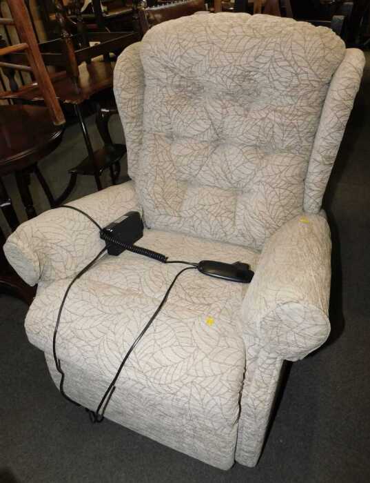 An electric rise and recline armchair, in light brown upholstery.