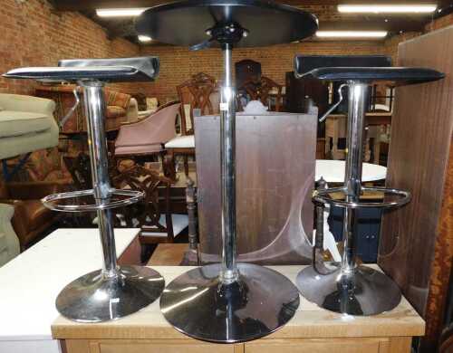 Furniture, comprising two chrome finished bar stools, and a circular chrome finished table.