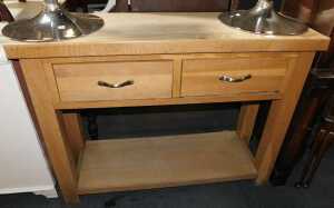 An oak and oak veneered kitchen unit, with two drawers and tier below, raised on square legs.