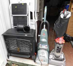 A Dyson DC33 vacuum cleaner, a Bissel carpet cleaner, a white step ladder and an electric stove....
