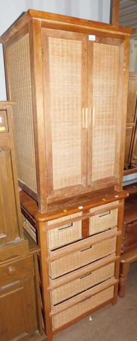A two door pine and caned unit, two doors opening to reveal shelves to interior, and a pine...