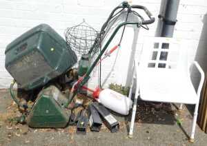 An Atco petrol lawn mower, a white finished plastic shower chair, four metal garden post spikes,...