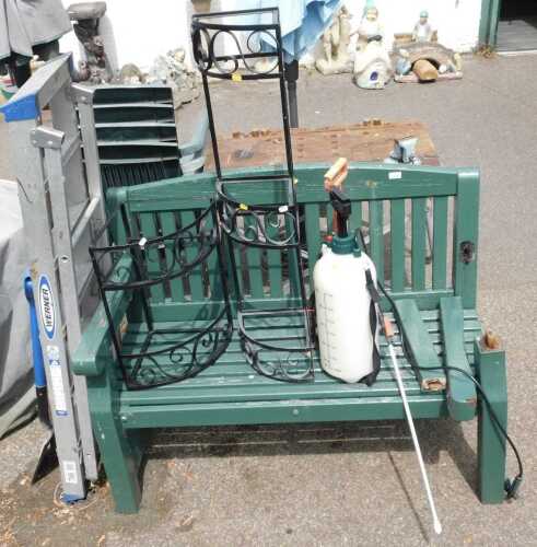 A green painted two seater garden bench, (AF), garden sprayers, two metal plant stands, a set of...