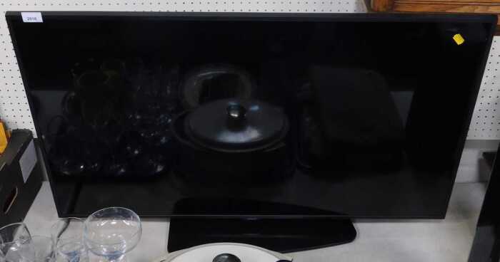 A Samsung flat screen TV, model number QB43Q8CRAT.