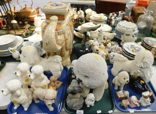 Ceramics, comprising Poodle figures, other dog figures, a mantel clock with eagle to top, and an...