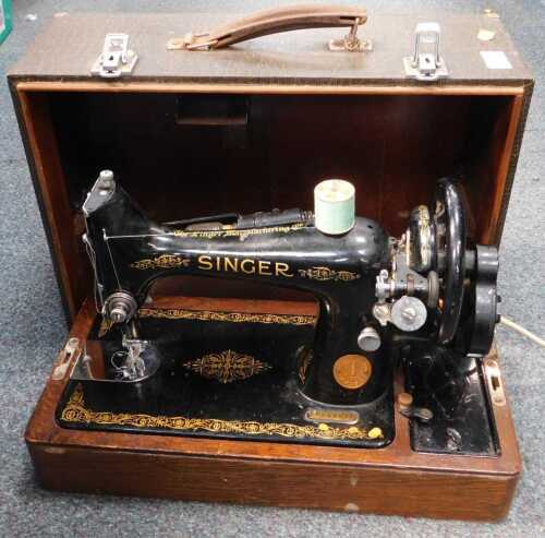A cased electric-operated Singer sewing machine. (under 1 table)