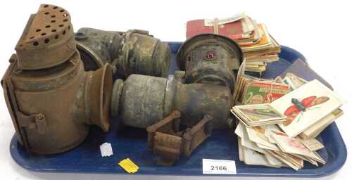 Two carbide vintage bicycle lamps, another, and a quantity of cigarette cards, etc. (1 tray)