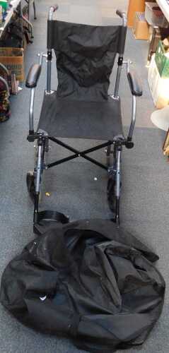 A folding wheelchair, in a canvas case.