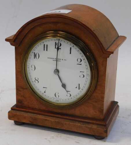 A burr wood cased mantel clock, the circular white enamel dial bearing Arabic numerals for...