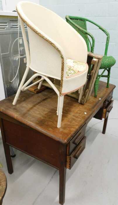 A 1920s oak desk, with sloping front and four pedestal drawers, a Lloyd Loom style chair,...